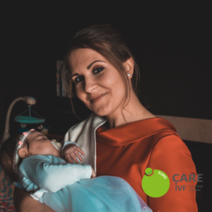 Single mom in orange shirt holding baby girl from IVF Cyprus