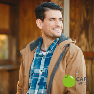 man standing in front of a wooden house